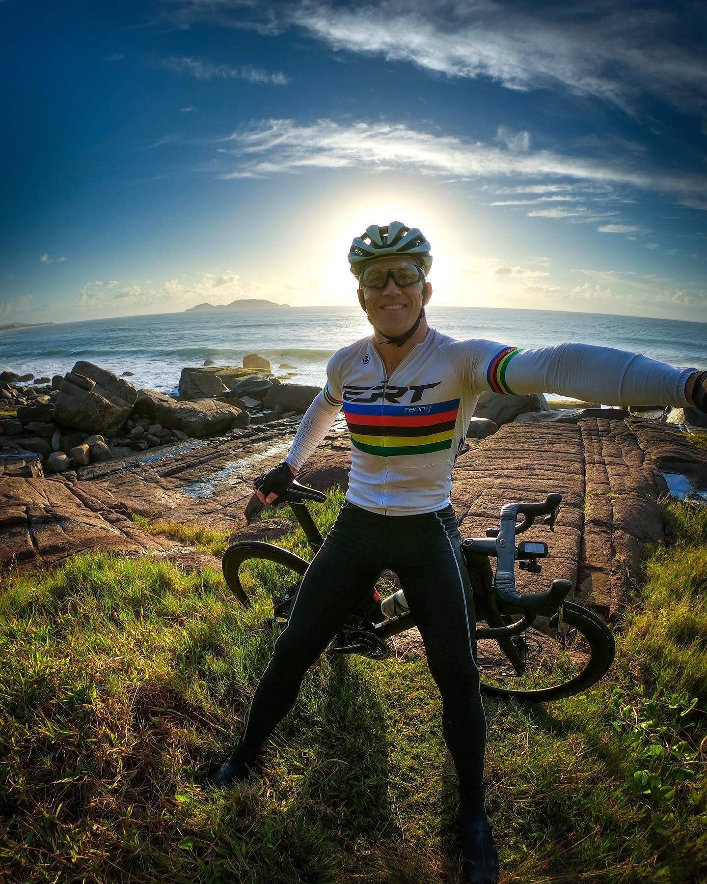 Parada no costão ao nascer do sol, com a bicicleta ao lado