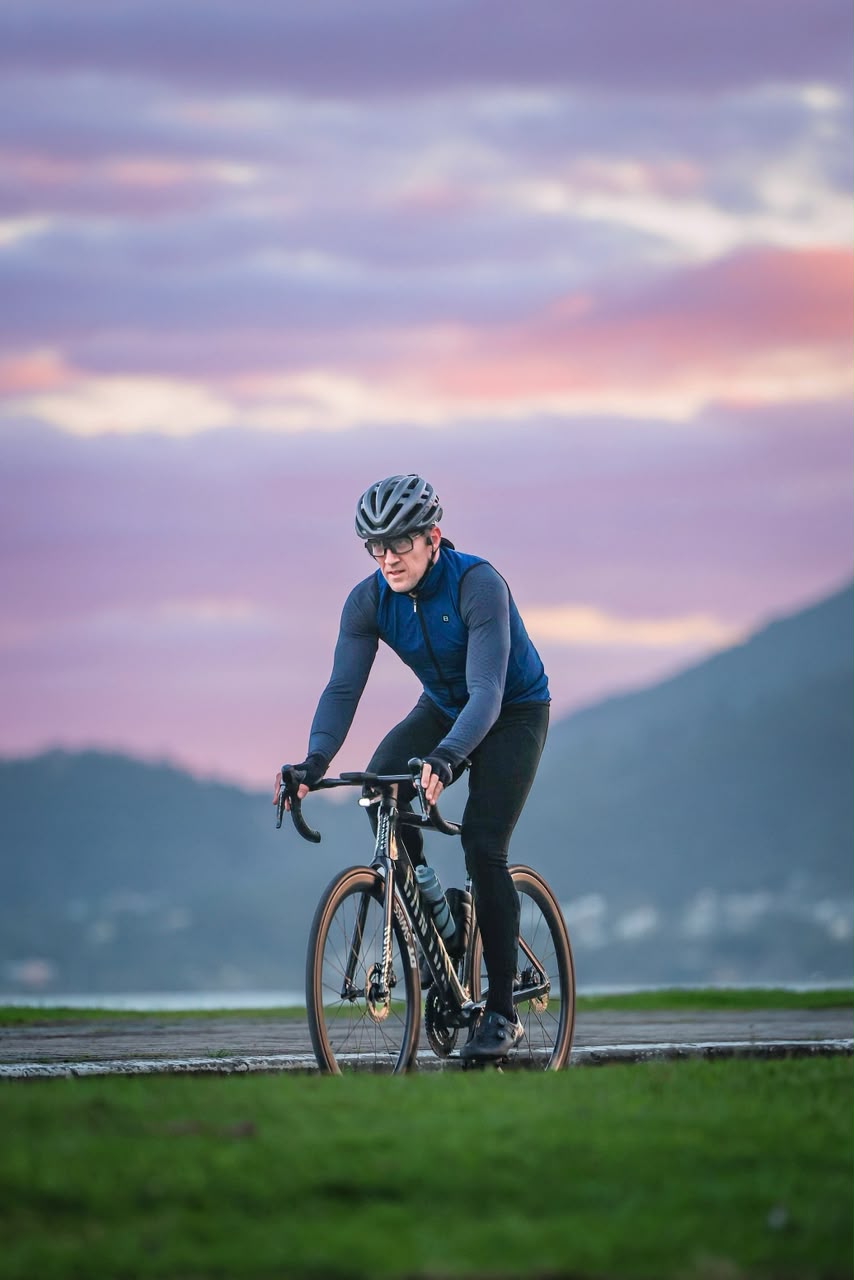 Pedalada ao entardecer, com o céu em tons de roxo e rosa